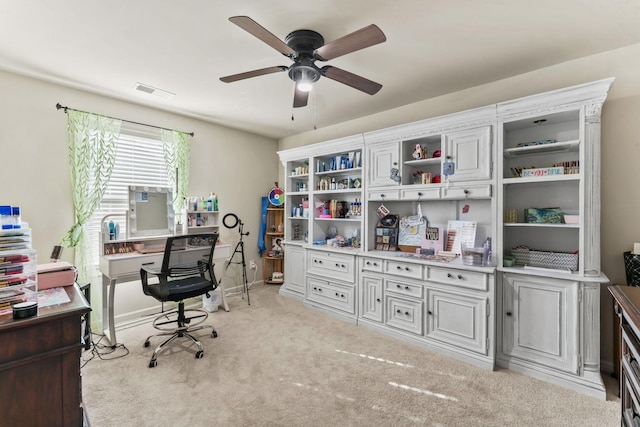 carpeted office space with ceiling fan