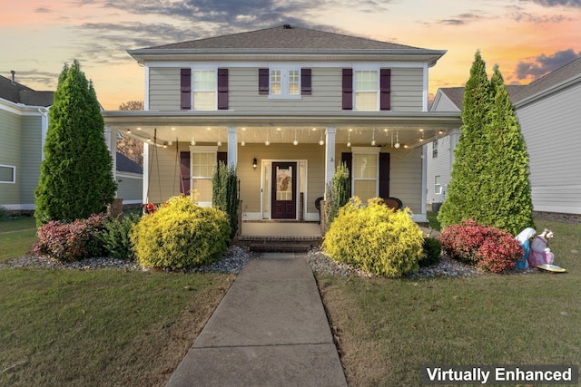 view of front of house with covered porch and a lawn