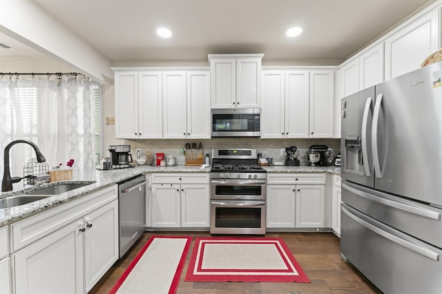 kitchen with sink, stainless steel appliances, white cabinets, and dark wood-type flooring