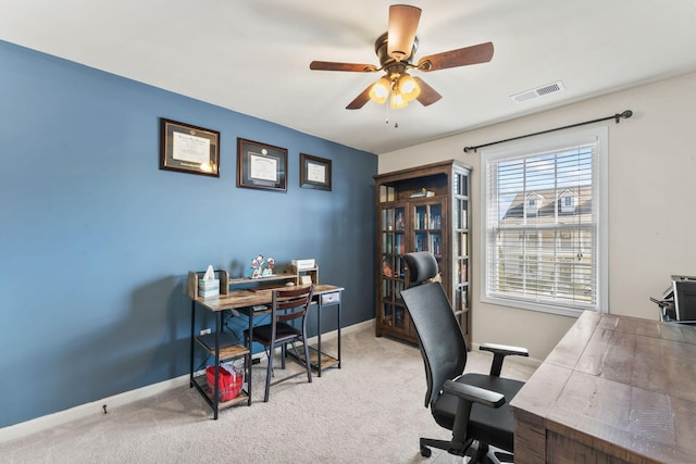 carpeted office space featuring ceiling fan