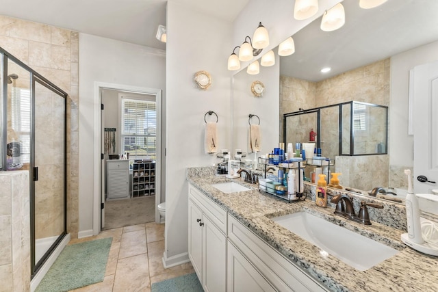 bathroom with toilet, tile patterned flooring, a shower with shower door, and vanity