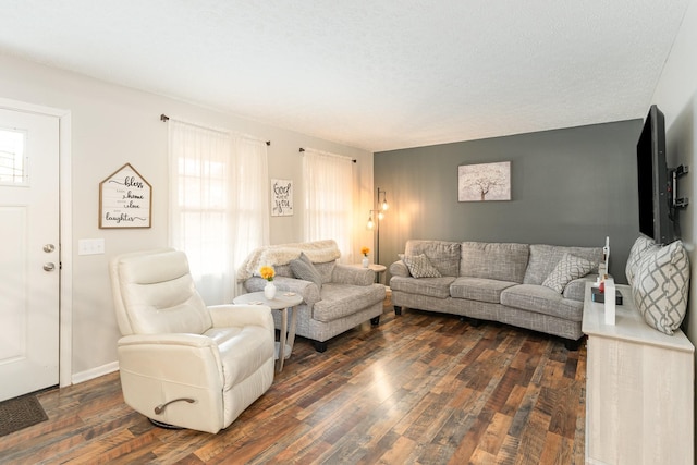 living room with a textured ceiling and dark wood-type flooring