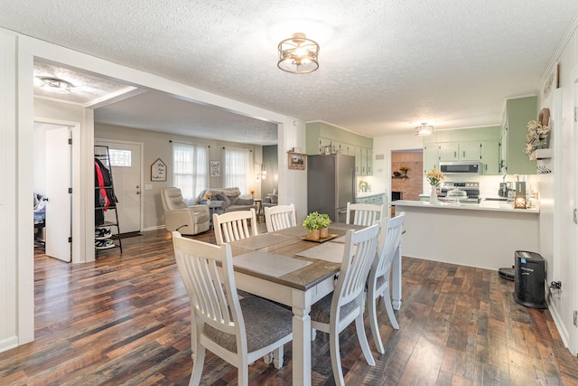 dining area featuring dark wood-type flooring and a textured ceiling