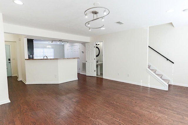 unfurnished living room featuring sink and dark wood-type flooring