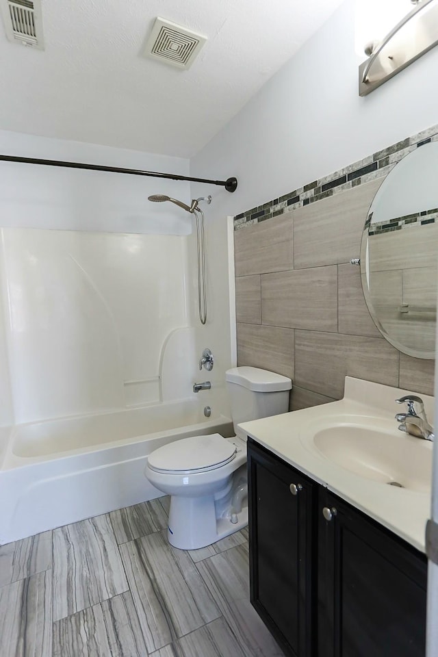 full bathroom featuring tile walls, shower / washtub combination, vanity, and toilet