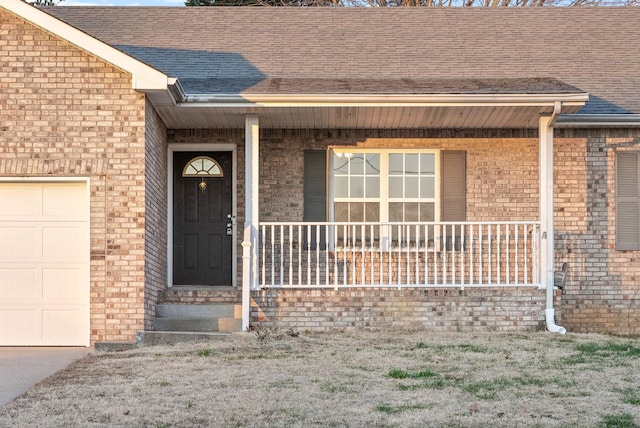 view of exterior entry featuring a porch and a garage