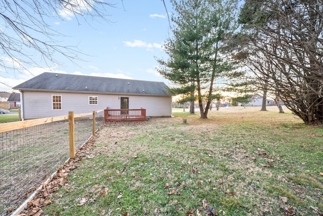 back of property featuring a wooden deck and a lawn