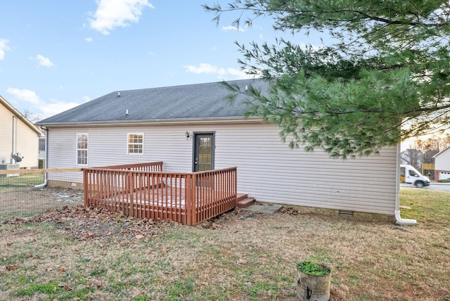 rear view of property featuring a deck and a lawn