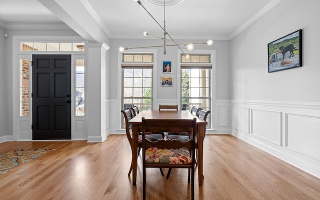 dining space with light wood-type flooring, crown molding, and a chandelier