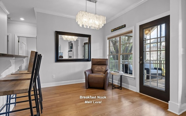 living area featuring ornamental molding, hardwood / wood-style floors, and a chandelier