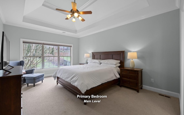 carpeted bedroom featuring ceiling fan, a tray ceiling, and ornamental molding