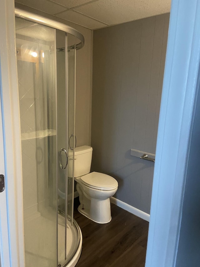 bathroom with an enclosed shower, hardwood / wood-style floors, a paneled ceiling, and toilet