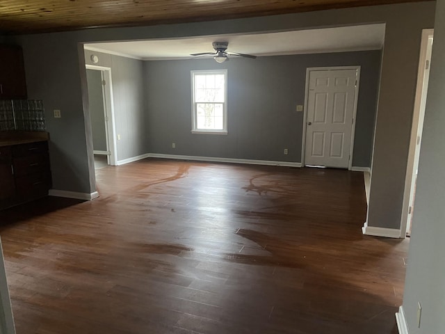 empty room with crown molding, dark wood-type flooring, and ceiling fan