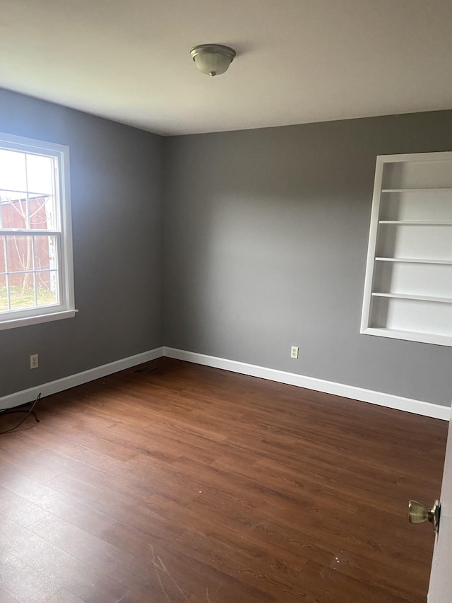 spare room with dark hardwood / wood-style flooring