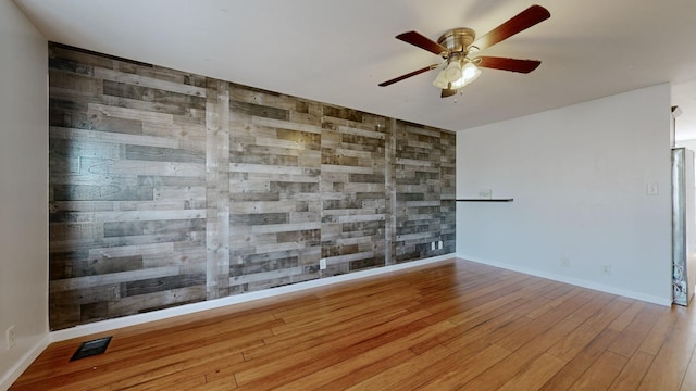 spare room with ceiling fan and light wood-type flooring