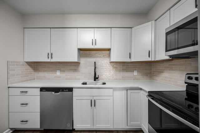 kitchen featuring sink, white cabinets, tasteful backsplash, and appliances with stainless steel finishes