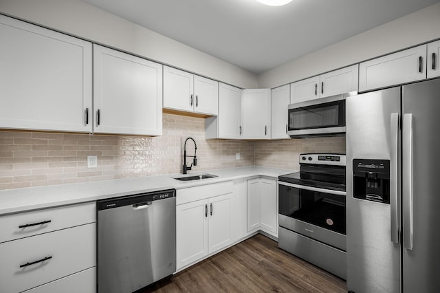 kitchen featuring stainless steel appliances, white cabinets, tasteful backsplash, and sink