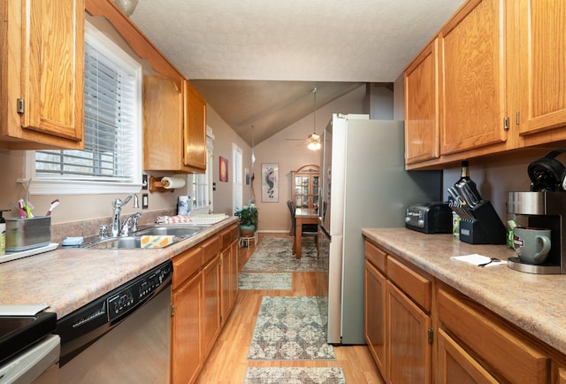 kitchen with sink, vaulted ceiling, dishwasher, ceiling fan, and light wood-type flooring