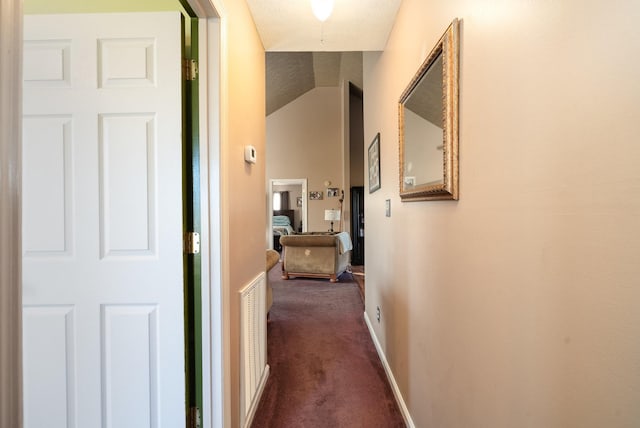 hallway with dark colored carpet