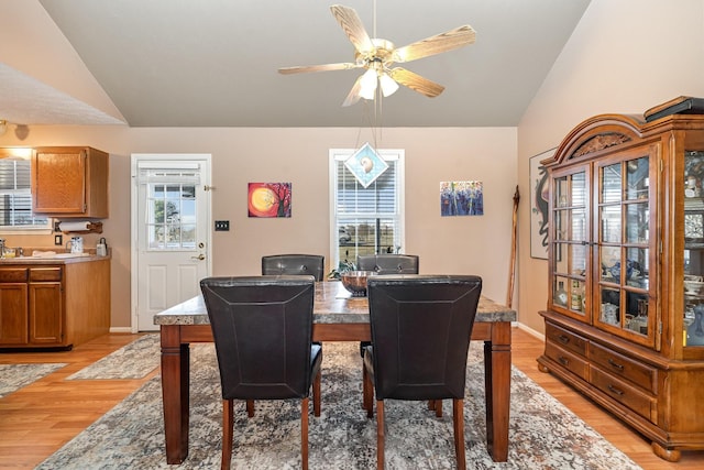 dining area with ceiling fan, light hardwood / wood-style flooring, and lofted ceiling