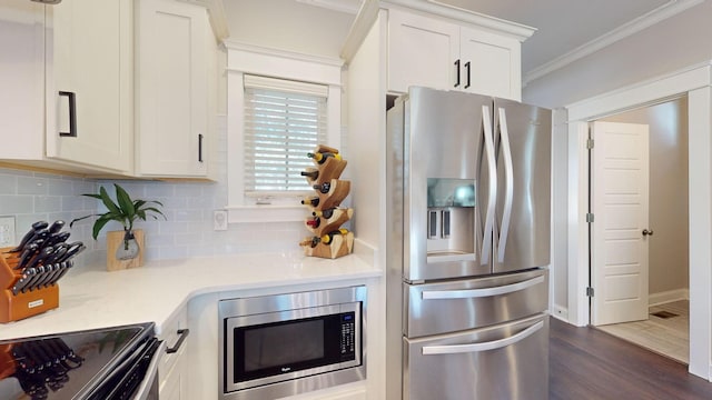 kitchen featuring stainless steel appliances, crown molding, dark hardwood / wood-style flooring, white cabinetry, and tasteful backsplash