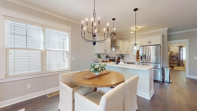 dining room featuring sink, an inviting chandelier, crown molding, and dark hardwood / wood-style floors