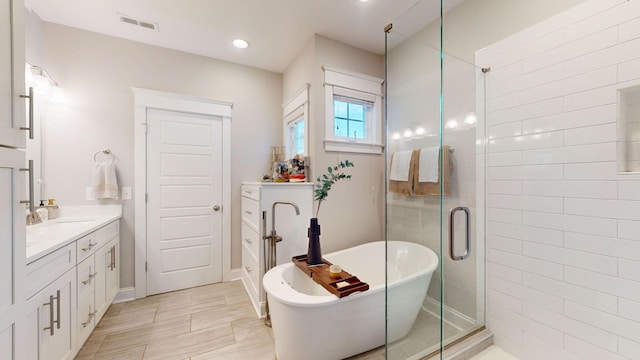 bathroom featuring plus walk in shower and vanity