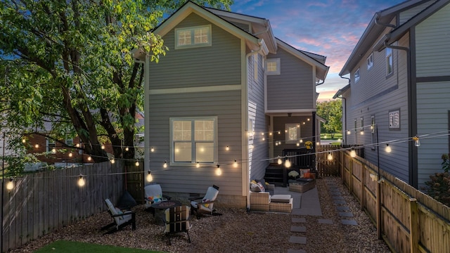 back house at dusk featuring a patio area