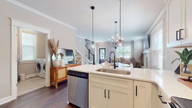 kitchen featuring stainless steel dishwasher, ornamental molding, washer and clothes dryer, and sink