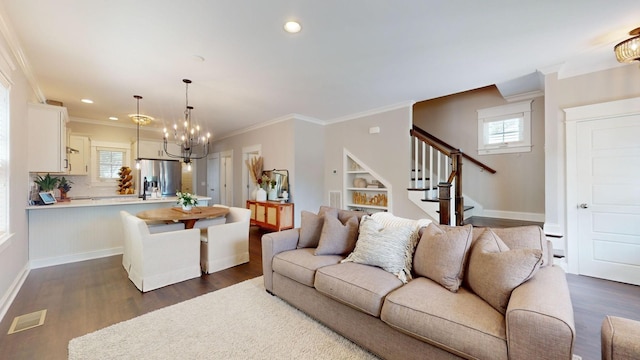 living room with built in shelves, ornamental molding, a wealth of natural light, and dark hardwood / wood-style floors