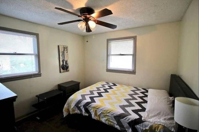 bedroom with ceiling fan and a textured ceiling