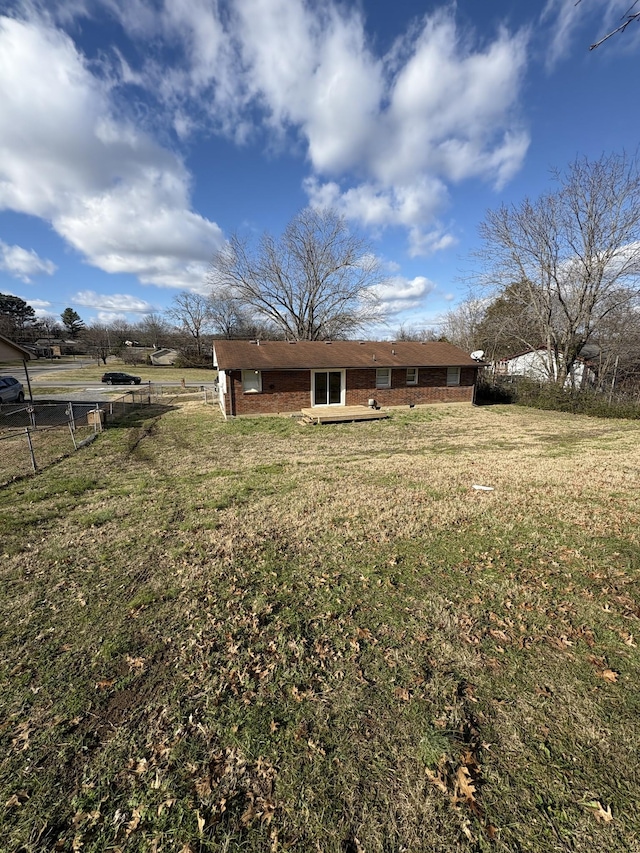 back of property with a rural view and a lawn