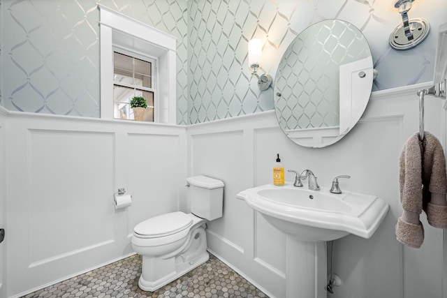 bathroom with toilet, tile patterned flooring, and sink