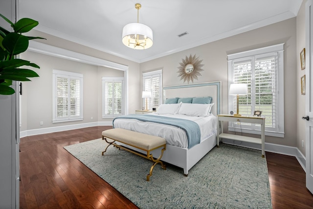 bedroom featuring dark hardwood / wood-style flooring, multiple windows, and crown molding