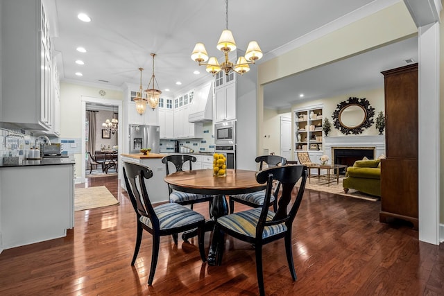 dining area with a notable chandelier, dark wood-type flooring, ornamental molding, and built in features