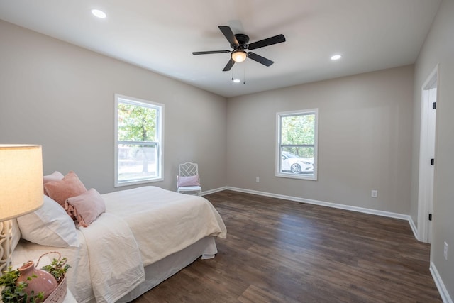 bedroom with ceiling fan, dark hardwood / wood-style flooring, and multiple windows