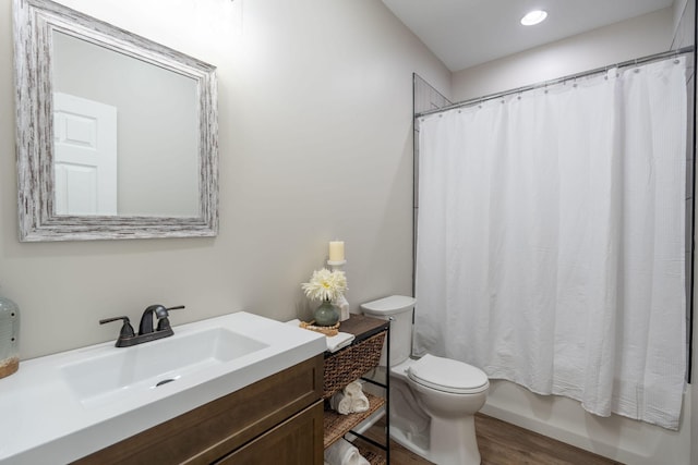 full bathroom featuring shower / bath combo, hardwood / wood-style flooring, vanity, and toilet