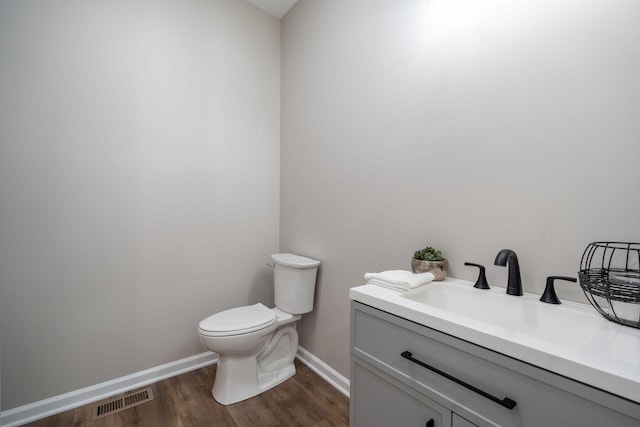 bathroom with hardwood / wood-style flooring, vanity, and toilet