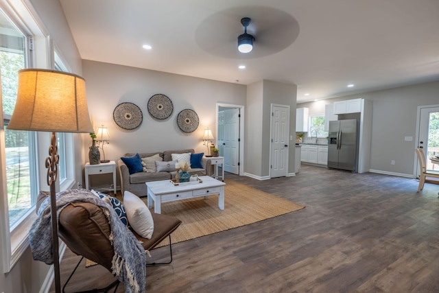 living room featuring ceiling fan, a healthy amount of sunlight, sink, and dark hardwood / wood-style floors