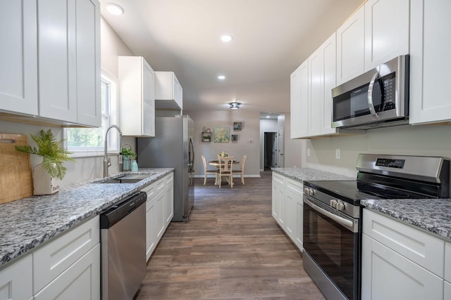 kitchen with sink, stainless steel appliances, white cabinetry, and dark wood-type flooring