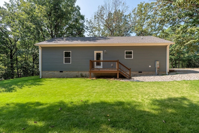 rear view of house featuring a deck and a lawn