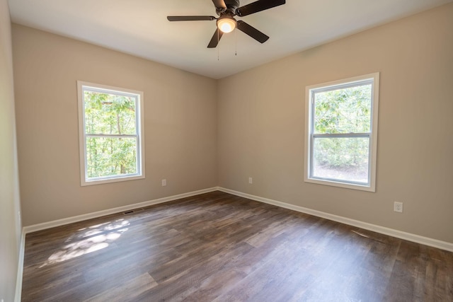 spare room featuring ceiling fan, a wealth of natural light, and dark hardwood / wood-style floors