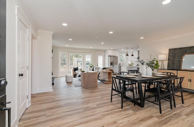 dining area featuring light hardwood / wood-style floors and crown molding