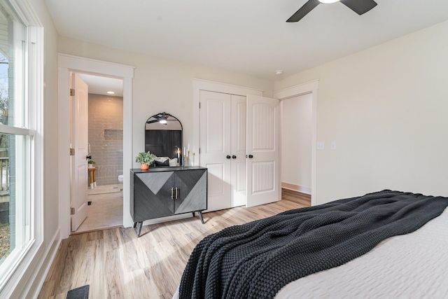 bedroom with ensuite bathroom, ceiling fan, light hardwood / wood-style flooring, and a closet