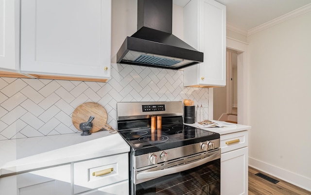 kitchen with stainless steel range with electric cooktop, white cabinets, ornamental molding, light hardwood / wood-style floors, and range hood