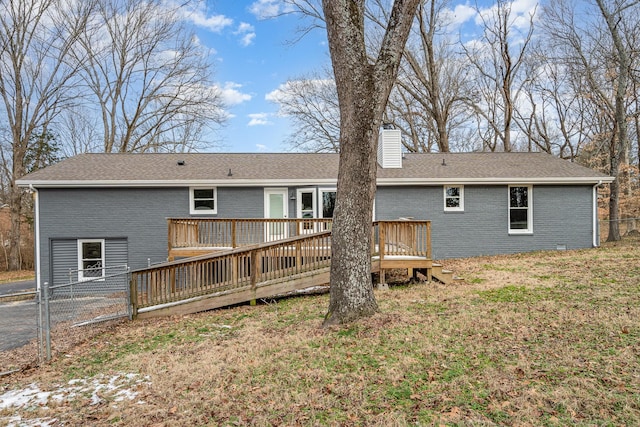 back of property with a yard and a wooden deck