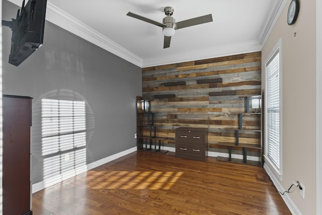 interior space with ceiling fan, dark hardwood / wood-style flooring, ornamental molding, and wood walls