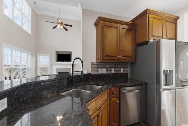 kitchen featuring dark stone countertops, appliances with stainless steel finishes, ceiling fan, sink, and tasteful backsplash