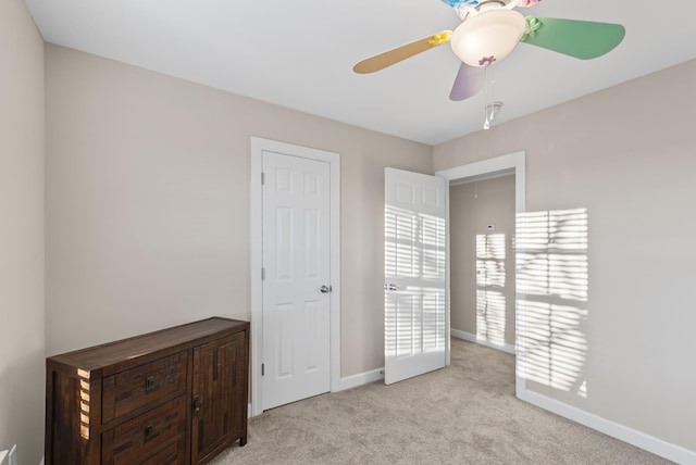 unfurnished bedroom featuring ceiling fan and light carpet