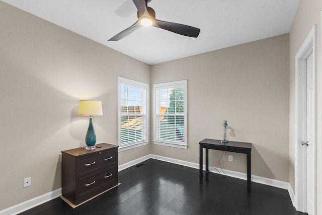 misc room with dark wood-type flooring and ceiling fan